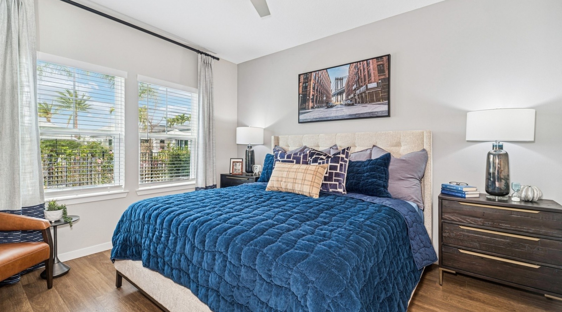 Relax and recharge in beautiful and spacious bedrooms a bedroom with a bed and a sidetable and large windows