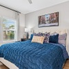 a bedroom with a bed and a sidetable and large windows