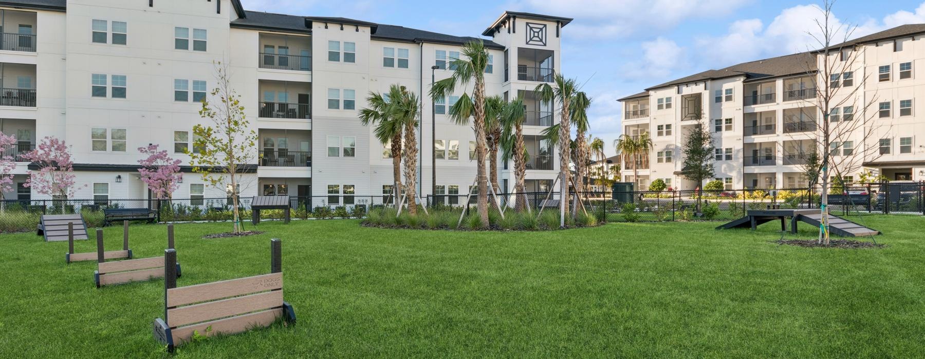 a white building with trees and a lawn in front of it