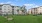 a white building with trees and a lawn in front of it