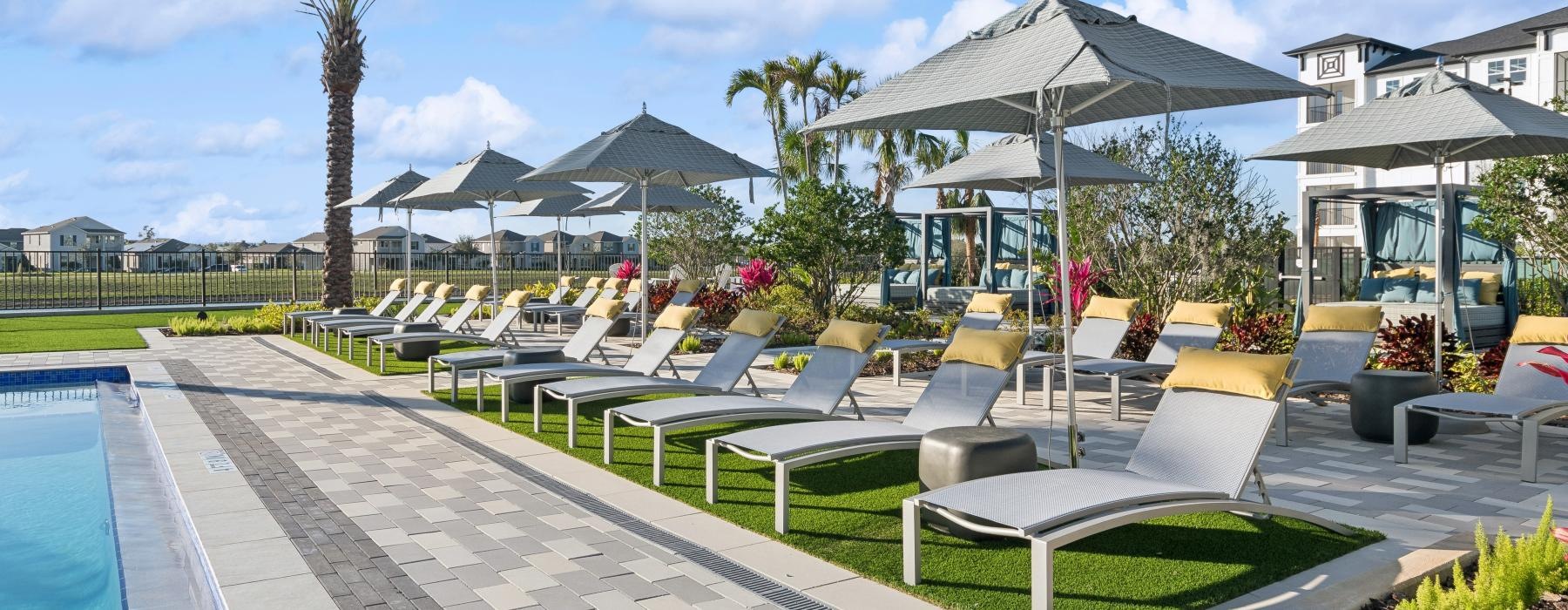 a pool with lounge chairs and umbrellas