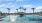 a pool with palm trees and a gazebo in the background