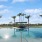 a pool with palm trees and a gazebo in the background