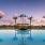 a pool with palm trees and a sunset